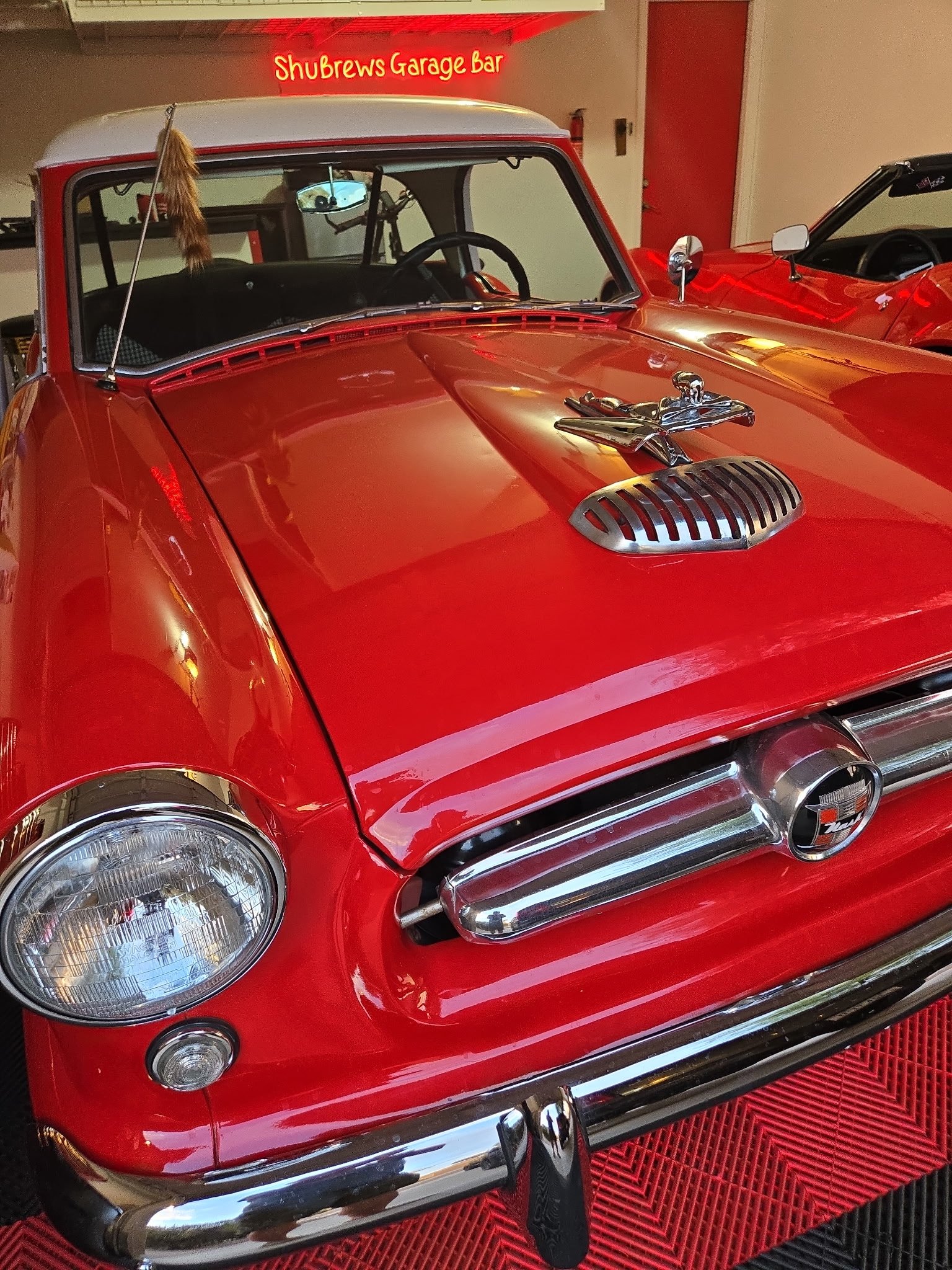 Restored red vintage car with chrome details displayed in ShuBrews Garage Bar showroom in Phoenix.